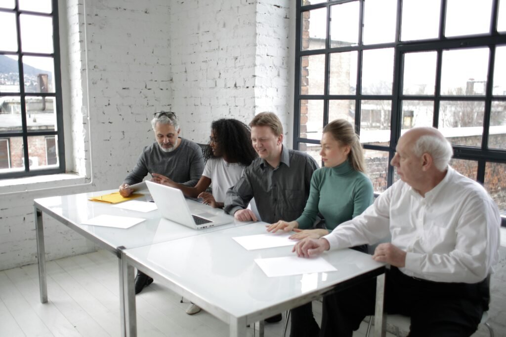 A group of professionals discussing ideas around a table in a bright, modern office setting.